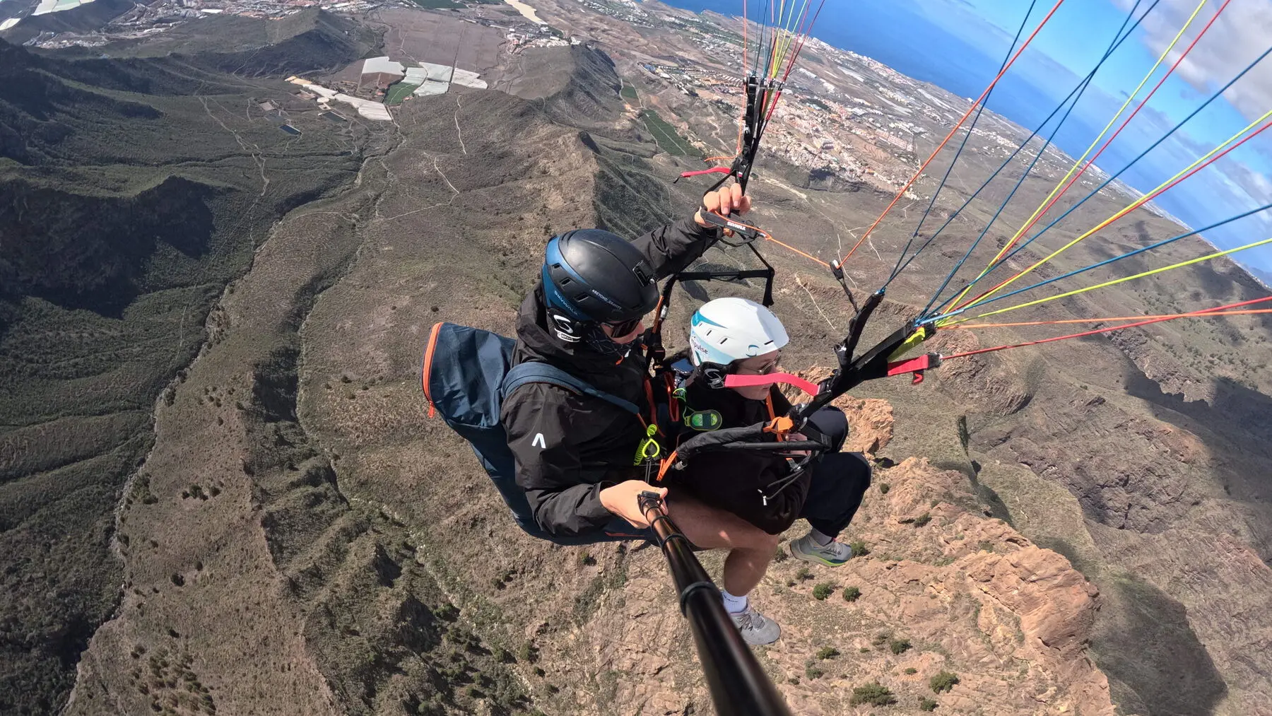 Tandem launch above the rocky ridge near Ifonche with the south coast of Tenerife behind