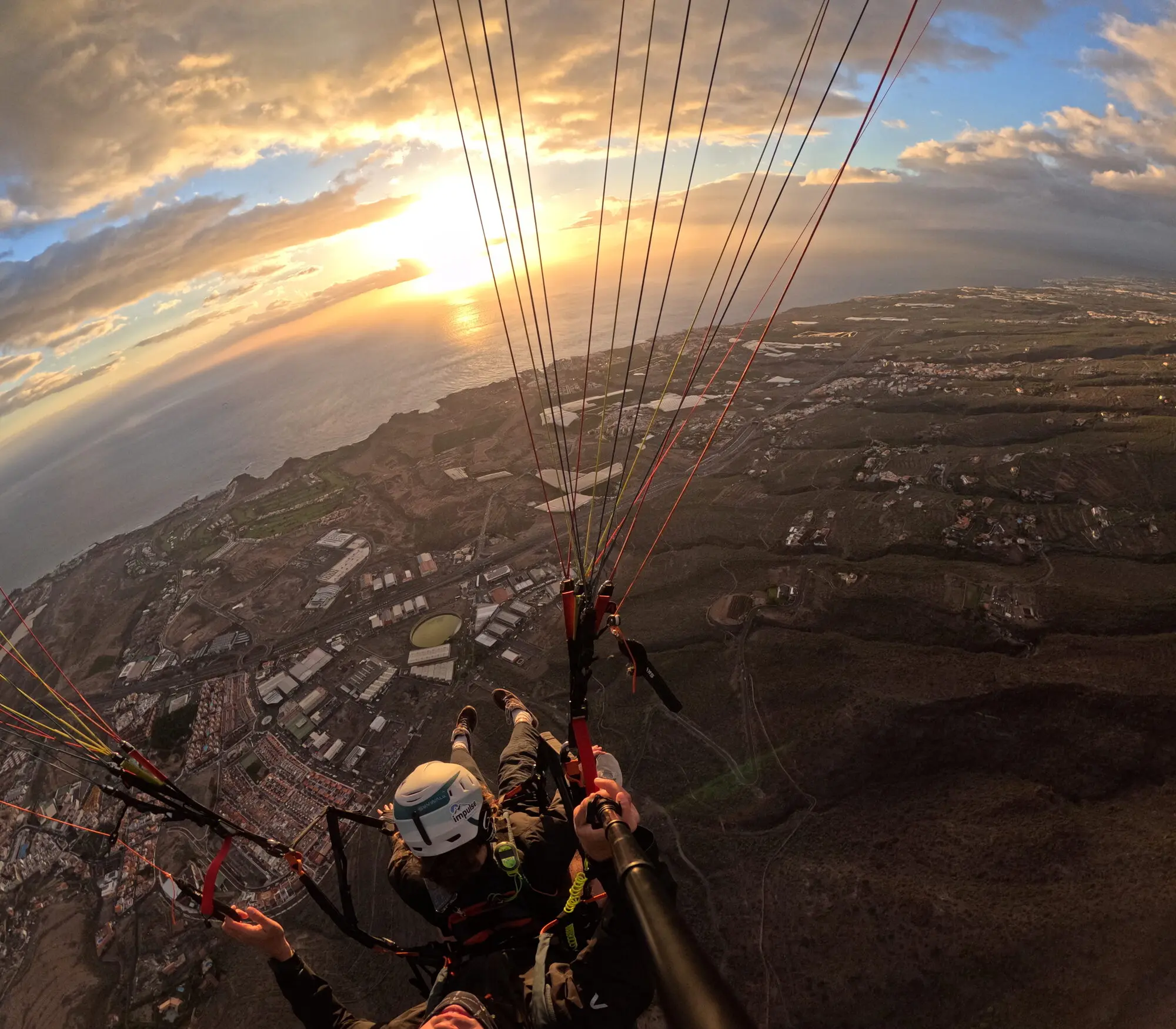 Legs dangling over Costa Adeje at golden hour, sunset over the Atlantic
