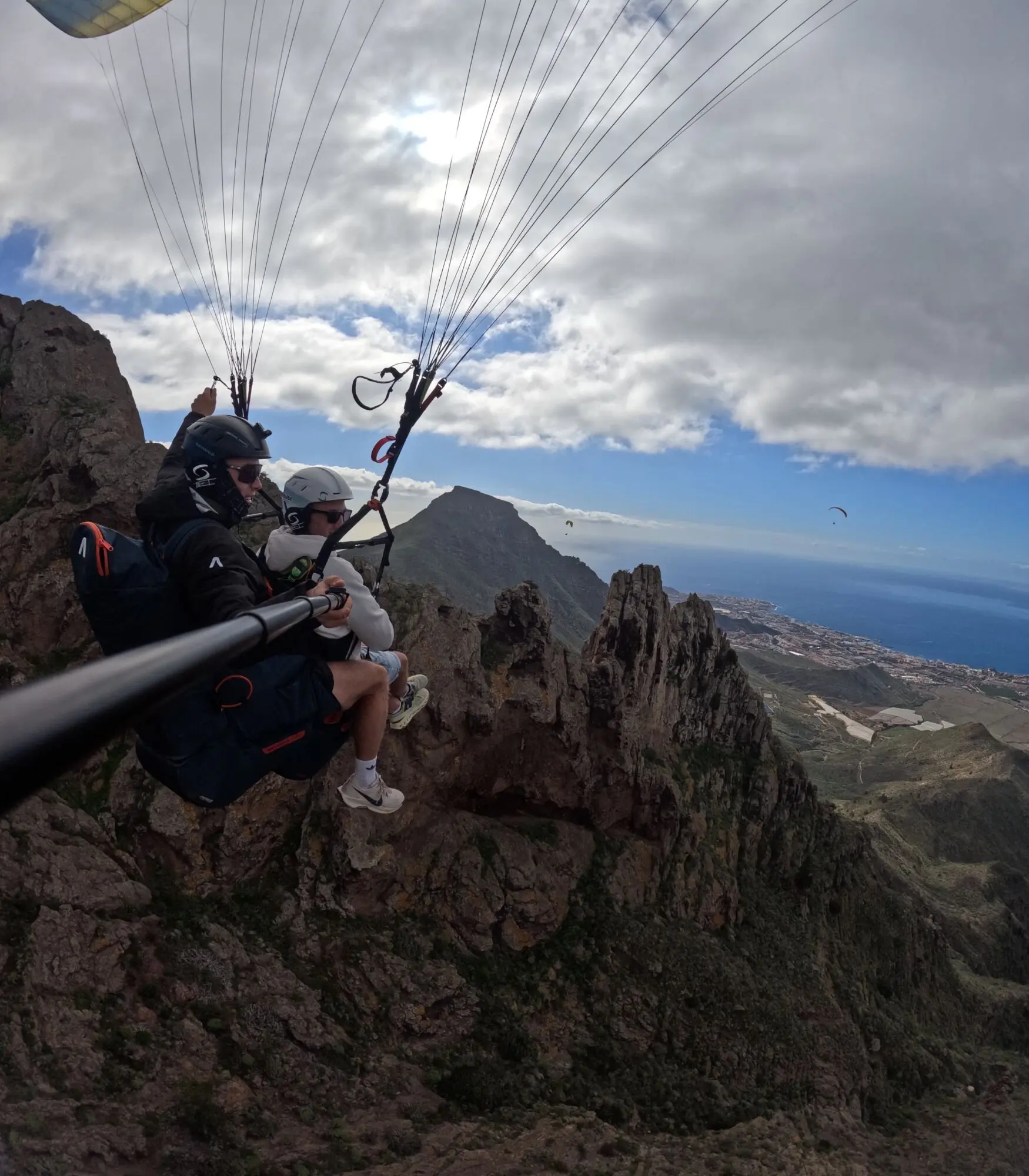 Tandem launch above the rocky ridge near Ifonche with the south coast of Tenerife behind